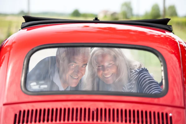 Casal sênior com carro vintage — Fotografia de Stock