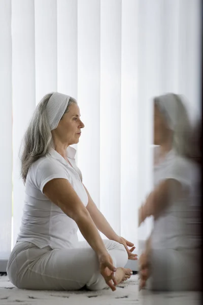 Donna anziana che fa yoga Immagine Stock