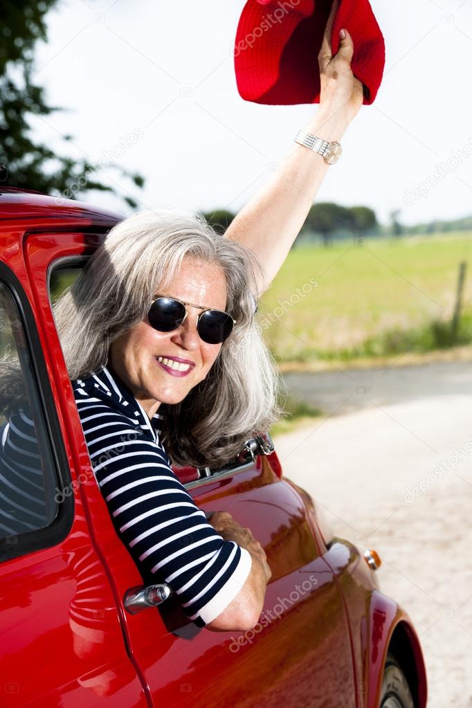 Senior woman with vintage car
