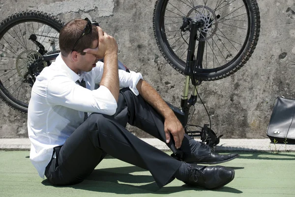 Businessman having troubles with his bike — Stock Photo, Image