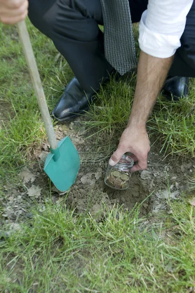 Geschäftsmann gräbt Ersparnisse aus — Stockfoto