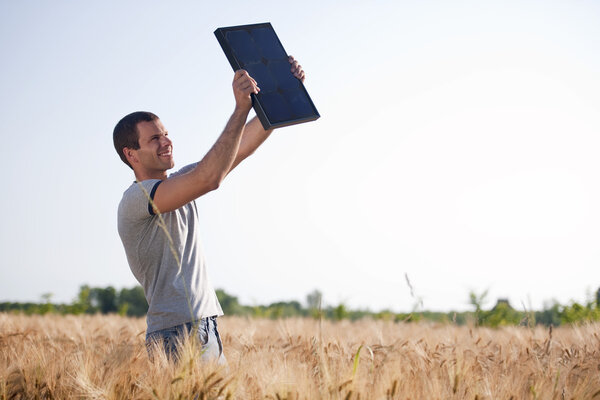 Young man holding a solar panel