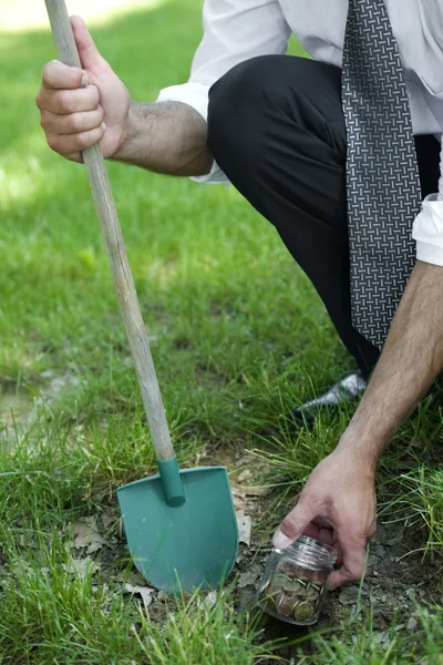 Geschäftsmann gräbt Ersparnisse aus — Stockfoto