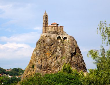 Ancient Chapelle Saint Michel de Aiguilhe standing at a very steep volcanic needle (Le Puy en Velay, France) clipart