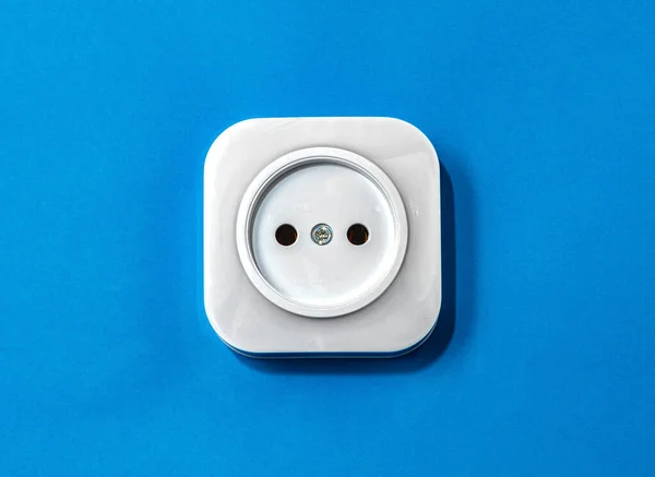 蓝色底座上的电动白色塑料插座 — 图库照片