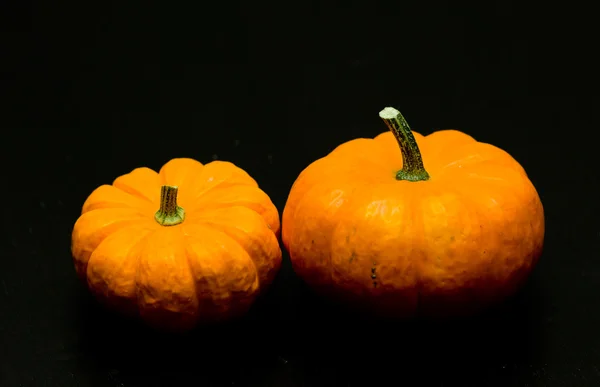 Calabazas amarillas sobre mesa negra — Foto de Stock