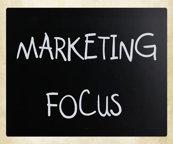 "Marketing focus" handwritten with white chalk on a blackboard — Stock Photo, Image
