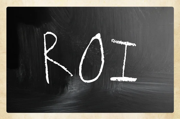 The word "ROI" handwritten with white chalk on a blackboard — Stock Photo, Image