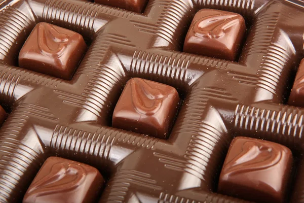 Bonbons au chocolat empilés sur fond blanc — Photo