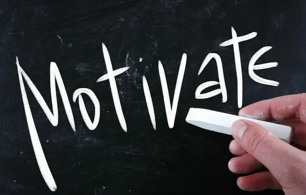 "Motivate" handwritten with white chalk on a blackboard — Stock Photo, Image