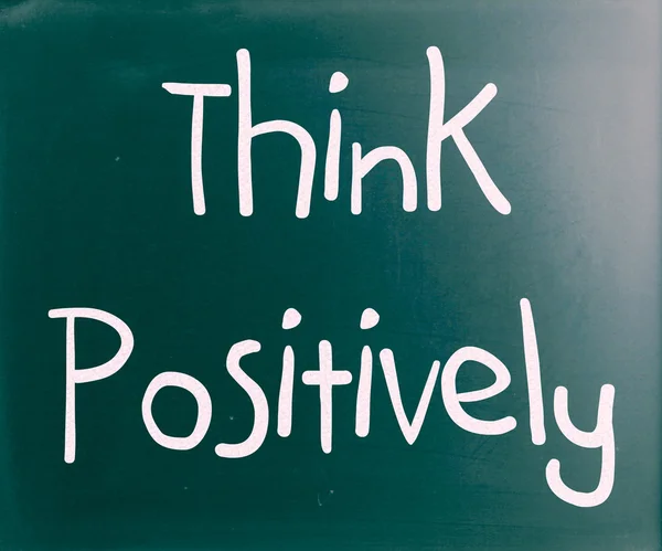 "Myslet pozitivně"rukou s bílou křídou na tabuli — Stock fotografie