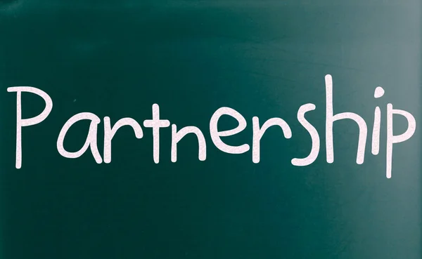 Le mot "Partenariat" écrit à la main avec de la craie blanche sur un blackbo — Photo