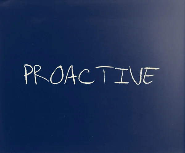 Écrit "proactif" à la craie blanche sur un tableau noir — Photo