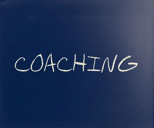 "Coaching "handskriven med vit krita på en svart tavla — Stockfoto
