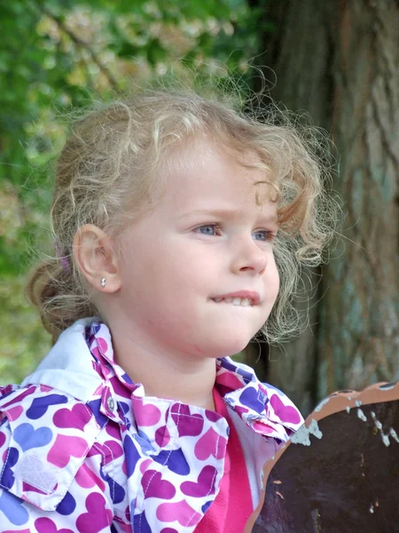 Nettes kleines Mädchen spielt mit Blättern im Herbstpark — Stockfoto