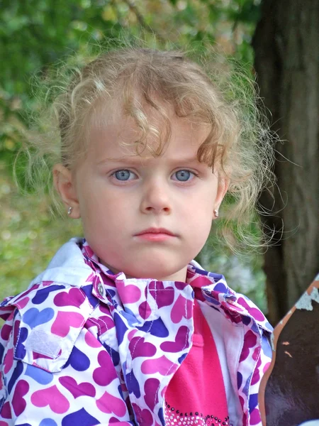 Menina bonito está brincando com folhas no parque de outono — Fotografia de Stock