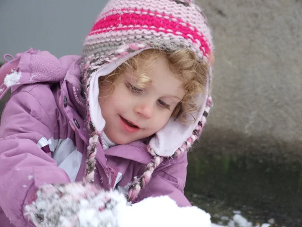 Een mooi jong meisje plezier spelen in de sneeuw — Stockfoto