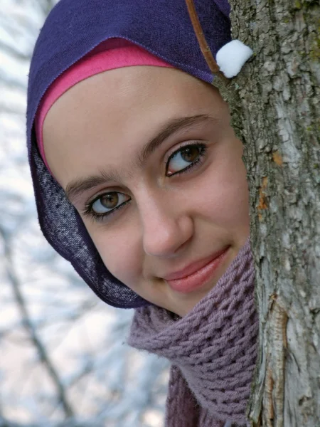 Uma bela jovem garota se divertindo jogando na neve — Fotografia de Stock