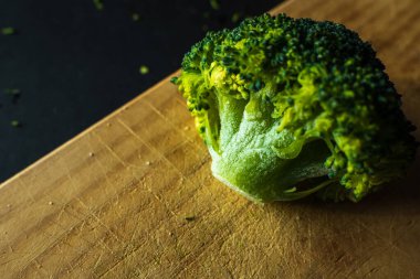 Koyu arkaplanda donmuş yeşil brokoli çiçekleri.