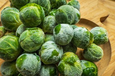 Donmuş buzlu Brüksel lahanası ahşap tabakta filizlenir.