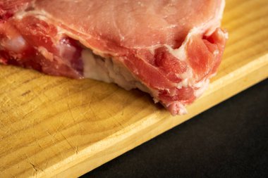 Tahta kesme tahtasında taze domuz pirzolası yakın plan..