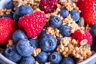 Taze çilekli granola yaban mersini ve ahududu yakından..