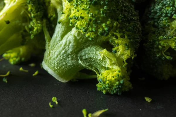 Koyu arkaplanda donmuş yeşil brokoli çiçekleri..
