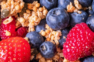 Taze çilekli granola yaban mersini ve ahududu yakından.