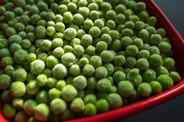 冷凍した緑のエンドウ豆を赤のセラミックボウルに閉じ込め — ストック写真