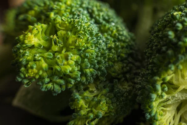 Floretas de brócolis verdes congeladas no fundo escuro closup — Fotografia de Stock
