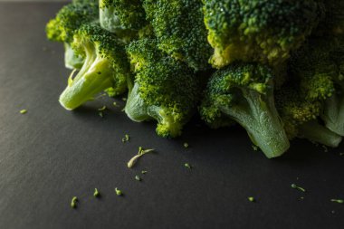 Koyu arkaplanda donmuş yeşil brokoli çiçekleri.