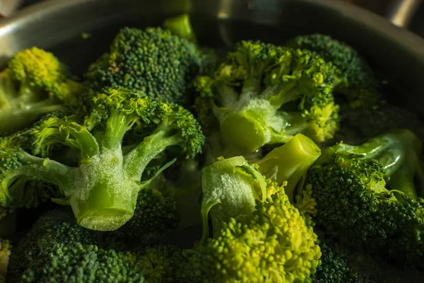 Frozen green broccoli florets inside pan casserole ready for boiling closup — Fotografia de Stock