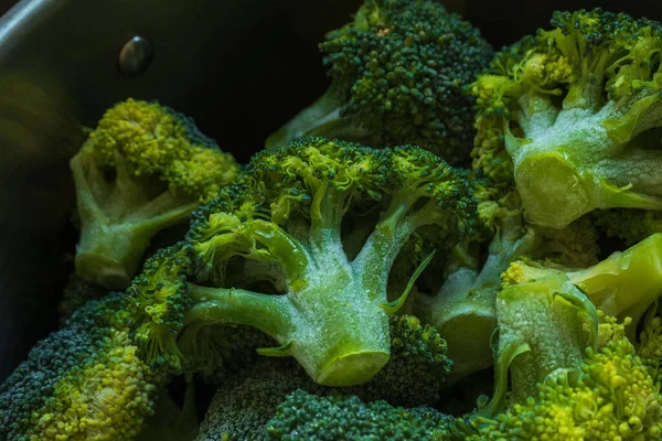 Floretos de brócolis verdes congelados dentro de caçarola de panela pronta para coágulo fervente — Fotografia de Stock