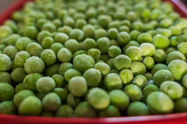 冷凍した緑のエンドウ豆を赤のセラミックボウルに閉じ込め — ストック写真