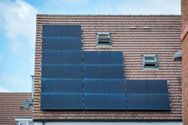 İngiltere 'de yeni inşa edilen modern bir evin çatısına güneş panelleri monte edildi..