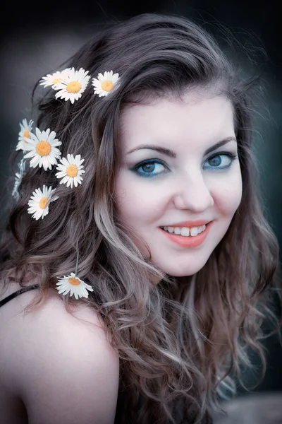 Jeune femme avec des fleurs dans les cheveux — Photo