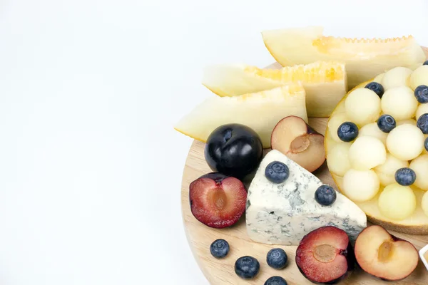 Various fruits on the plate. Melon, blueberries — Stock Photo, Image