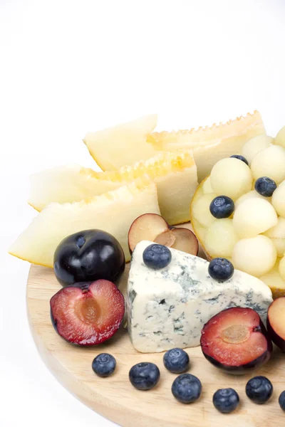 Various fruits on the plate. Melon, blueberries — Stock Photo, Image