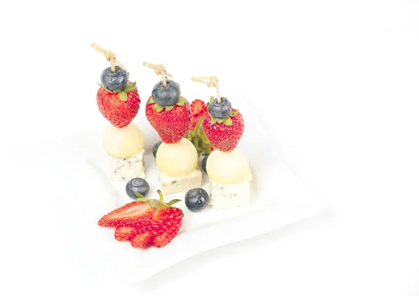 Canapés en un plato con melón de queso y fresas — Foto de Stock