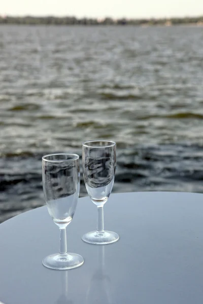 Bicchieri di vino sul tavolo contro — Foto Stock