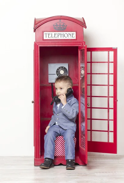 Little boy in English red phone — Stock Photo, Image