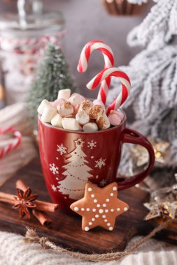 Bir fincan ve kurabiyeyle rahat bir Noel kompozisyonu. Şekerli sıcak çikolata..