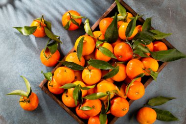 Tahta kutuda yaprakları olan taze mandalina portakalları..