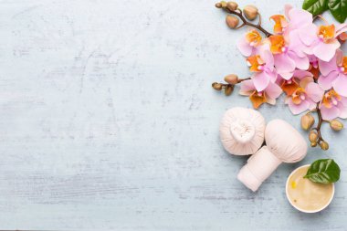 Spa aromaterapi arka planı, basit orkide çiçekleriyle süslenmiş çeşitli güzellik ürünleri..