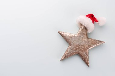 Noel yıldızı ve Noel Baba şapkası, pastel mavi arka planda dekor. 