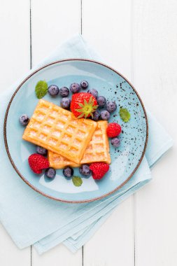Ahşap arka planda bir tabakta taze meyve salatası. Düz konum, üst görünüm, kopyalama alanı.