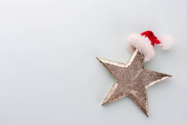 Noel yıldızı ve Noel Baba şapkası, pastel mavi arka planda dekor. 