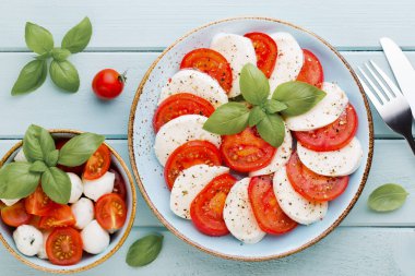 Domates, mozzarella peyniri, fesleğen ve baharatlar gri tahtada. İtalyan geleneksel Caprese salata malzemeleri. Akdeniz yemekleri.