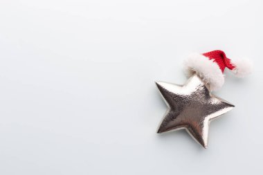 Noel yıldızı ve Noel Baba şapkası, pastel mavi arka planda dekor. 