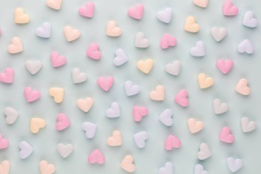 Sevgililer Günü geçmişi. Pastel mavi arka planda şeker kalpli kompozisyon. Sevgililer Günü tebrik kartı. Düz yatış, üst görünüm.